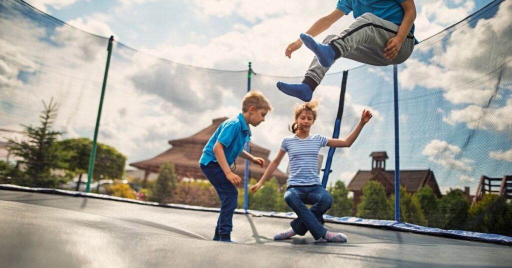 Børn hopper på trampolin i haven